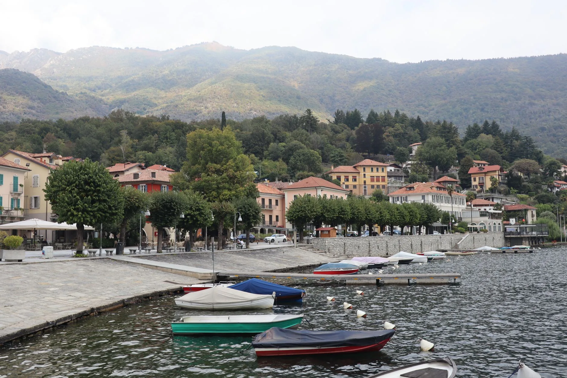 Village coloré au bord d'un lac italien avec bateaux amarrés