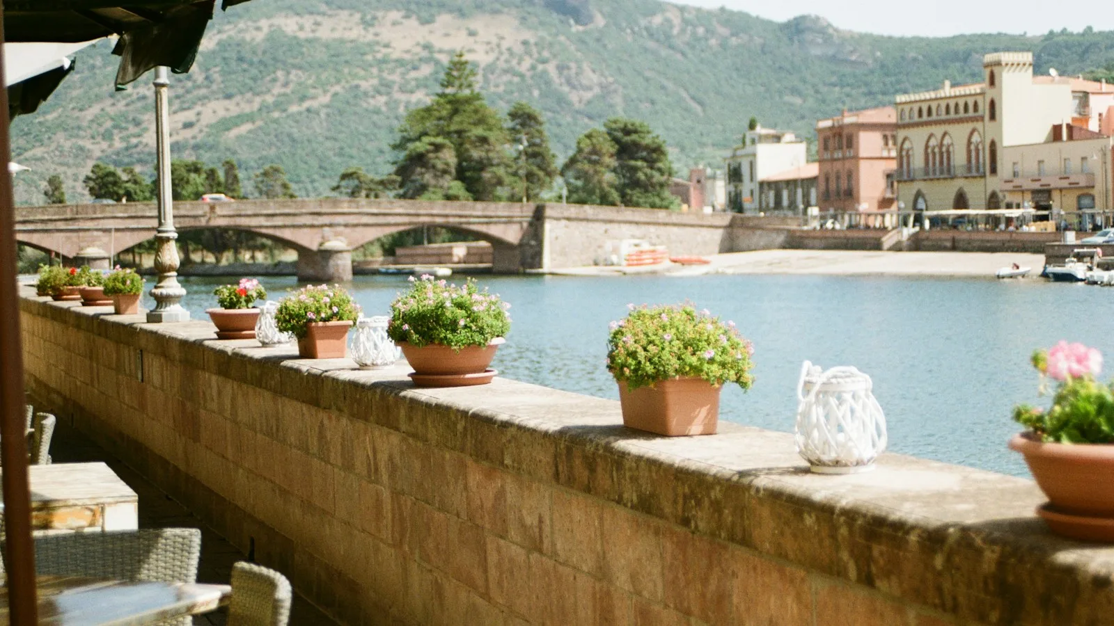Table dressée face à un lac italien avec poisson de lac et vin blanc